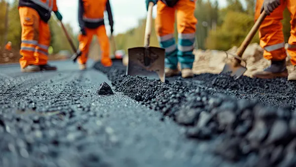 Image of a group of workers laying down asphalt