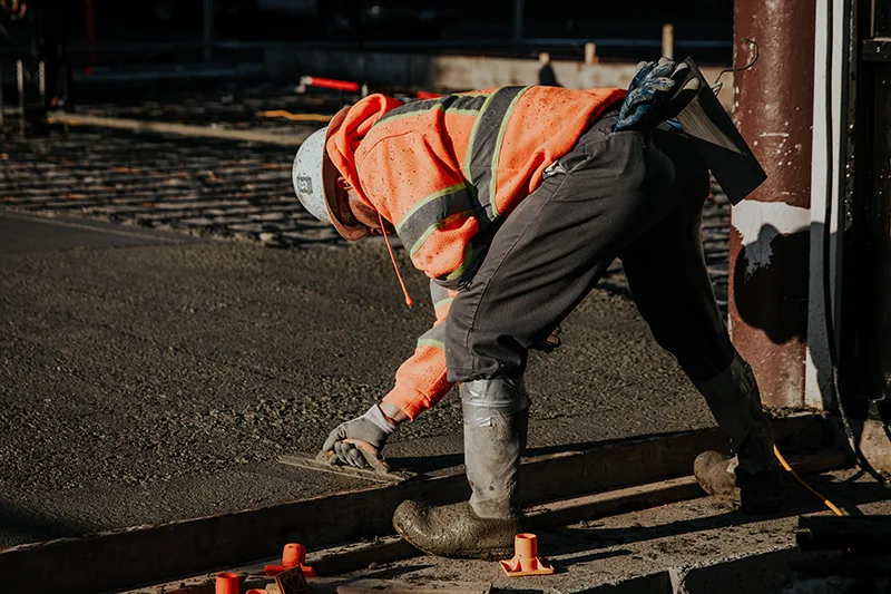 Construction worker smoothing concrete